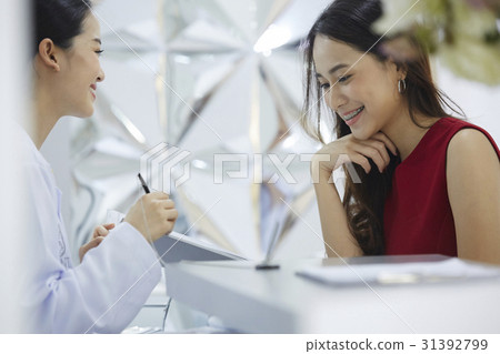 A young woman is looking at what her doctor showing. A young woman is looking at what her doctor showing. 31392799