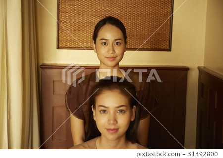 A photo of two woman in brown clothes looking at camera. A photo of two woman in brown clothes looking at camera. 31392800