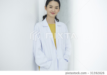 A doctor standing against the wall is looking at camera. A doctor standing against the wall is looking at camera. 31392826