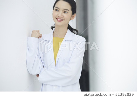 A beautiful doctor is folding arms, smiling and standing. A beautiful doctor is folding arms, smiling and standing. 31392829