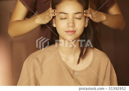 the girl is getting a head massage very comfotably in spa 31392952