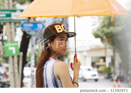 A girl with hat and umbrella is looking and thinking about something 31392971