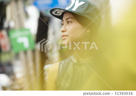 a blurred photo of a girl with snapback hat looking at something 31393016