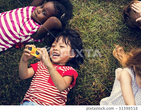 Group of kindergarten kids lying on the grass at park and relax Group of kindergarten kids lying on the grass at park and relax 31398518