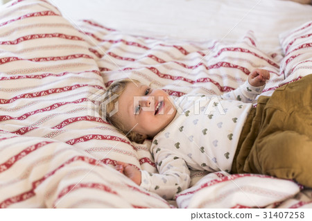 Cute little boy at home lying on bed smiling. 31407258