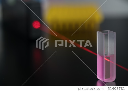 Quartz cuvette for laser chromatography with red liquid. Physical chemistry laboratory 31408781