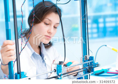 girl in robotics class research electronic device. Details of the machine with stepper motor girl in robotics class research electronic device. Details of the machine with stepper motor 31409372