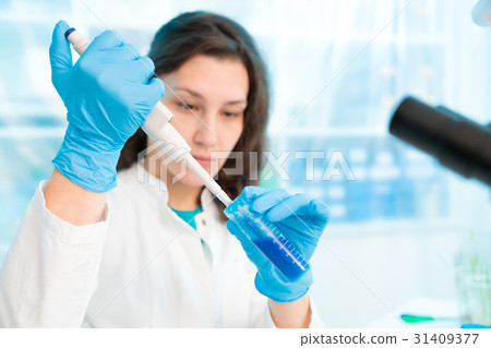 Woman technician with multipipette in genetic Woman technician with multipipette in genetic 31409377