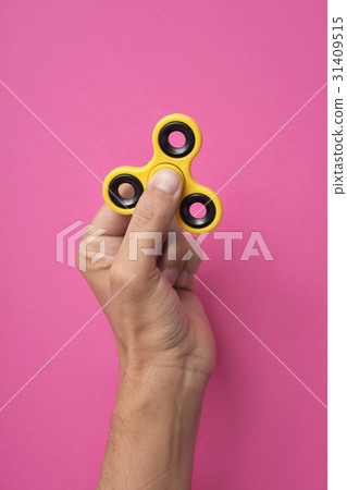 young man playing with a fidget spinner 31409515