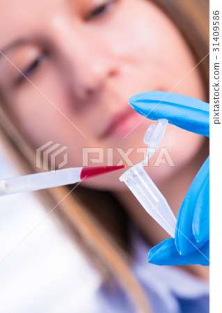 Woman technician with multipipette in Woman technician with multipipette in 31409586