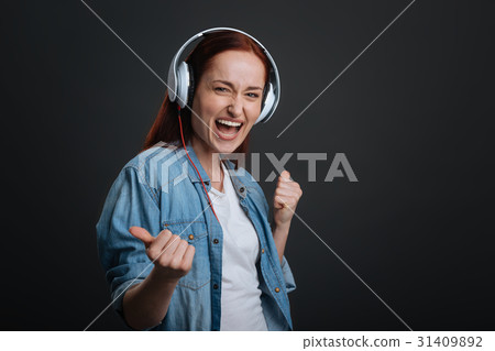 Active young lady enjoying loud sound 31409892