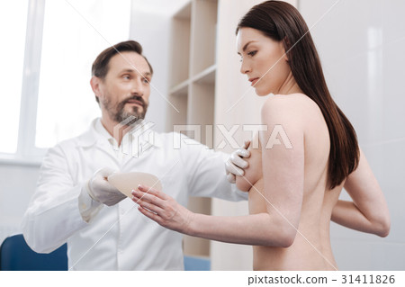 Wise plastic surgeon explaining how breast Wise plastic surgeon explaining how breast 31411826
