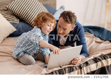 Little boy touching laptop of his father 31412708