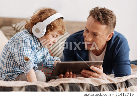 Very attentive boy looking at screen of the tablet 31412719
