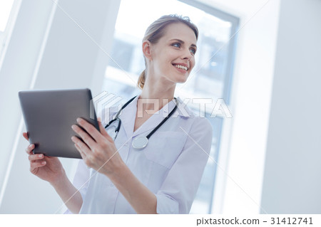 Energetic doctor holding electronic gadget in the 31412741
