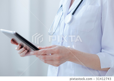 Skillful nurse using electronic gadget at work 31412743