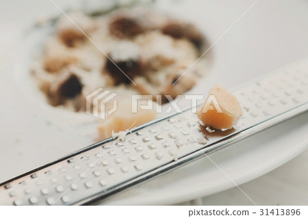 Grating parmesan cheese for italian cuisine dish Grating parmesan cheese for italian cuisine dish 31413896