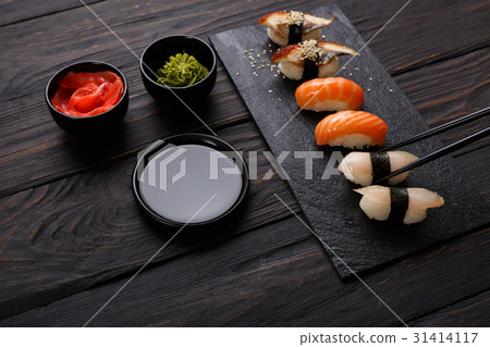Set of sushi on black wood background, closeup Set of sushi on black wood background, closeup 31414117