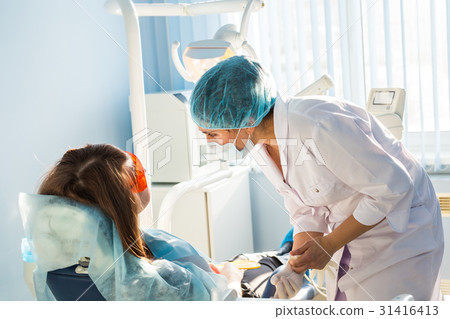 Woman at the dentist's chair during a dental Woman at the dentist's chair during a dental 31416413