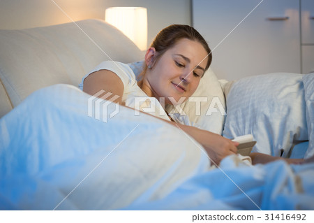 Woman using digital tablet in bed at night 31416492