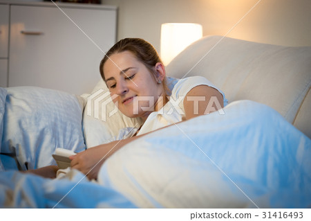 Woman reading on digital tablet at bed before 31416493
