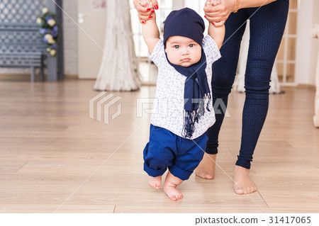 baby taking first steps with mother help 31417065