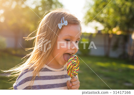 cute cauasian baby girl and big lollipop cute cauasian baby girl and big lollipop 31417166