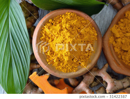 Turmeric powder in white cup on wooden Turmeric powder in white cup on wooden 31422387