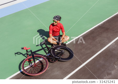 Athlete with a black bicycle at velodrome 31425241