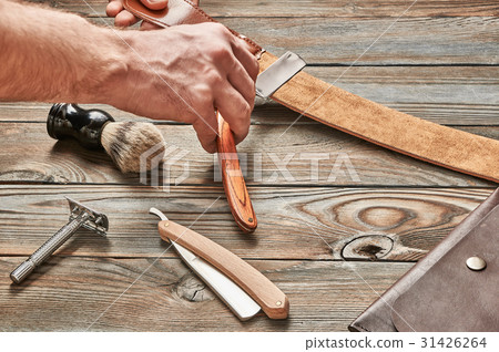 Man stropping straight razor 31426264