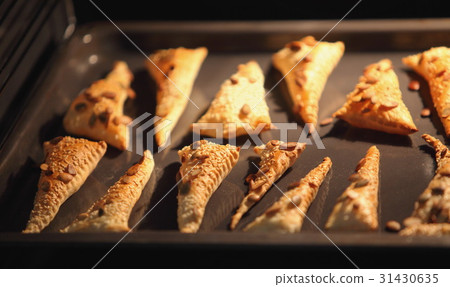 Triangles of puff pastry inside oven 31430635