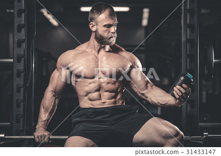 Handsome fit caucasian muscular man flexing his muscles in gym Handsome fit caucasian muscular man flexing his muscles in gym 31433147