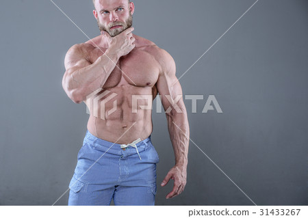 brutal muscular man in studio on gray background fitness model brutal muscular man in studio on gray background fitness model 31433267