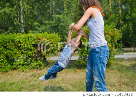 Happy family having fun outdoors. Mother holding Happy family having fun outdoors. Mother holding 31433438