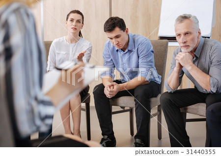 Serious adult people sitting on the chairs Serious adult people sitting on the chairs 31440355