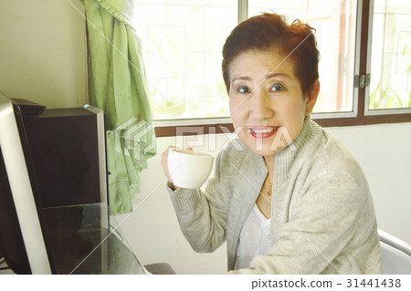 Asian elder woman enjoy her coffee while working 31441438