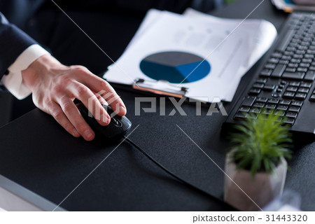 Adult employee in suit is holding gadget 31443320