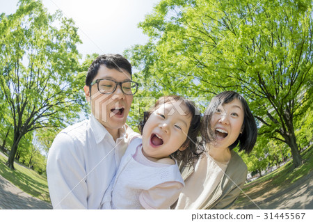 Three-person family playing in a fresh green park 31445567
