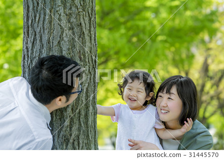 Three-person family playing in a fresh green park 31445570