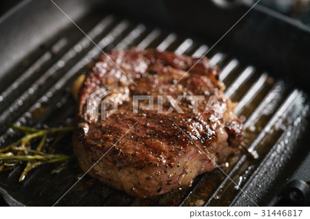 beef rib eye steak with rosemary on grill pan beef rib eye steak with rosemary on grill pan 31446817