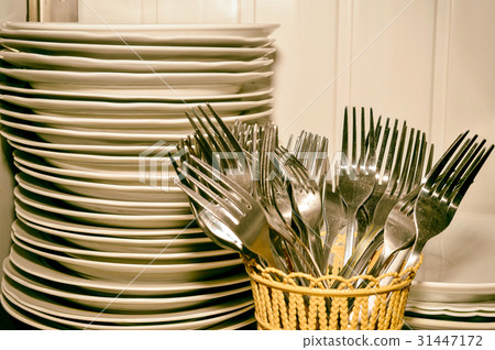 A stack of washed dishes and forks in the kitchen A stack of washed dishes and forks in the kitchen 31447172