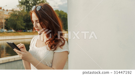 Serious ginger hair woman holding tablet 31447192