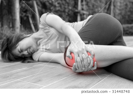 Asian woman runner touching her injured knee Asian woman runner touching her injured knee 31448748