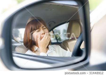 sleepy, tired young woman driving car 31448912