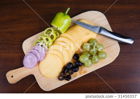 Sliced delicious cheese on wooden board Sliced delicious cheese on wooden board 31450357