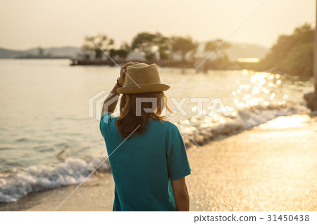 Young woman traveler walking on the beach Young woman traveler walking on the beach 31450438