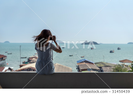 Young woman traveler sitting and take a photograph Young woman traveler sitting and take a photograph 31450439