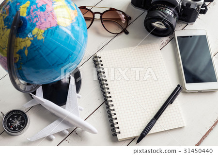 Traveler planning trip on notebook and smart phone Traveler planning trip on notebook and smart phone 31450440