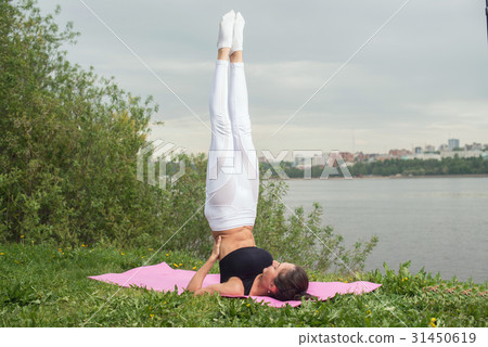 Fit woman making yoga in shoulderstand pose Fit woman making yoga in shoulderstand pose 31450619