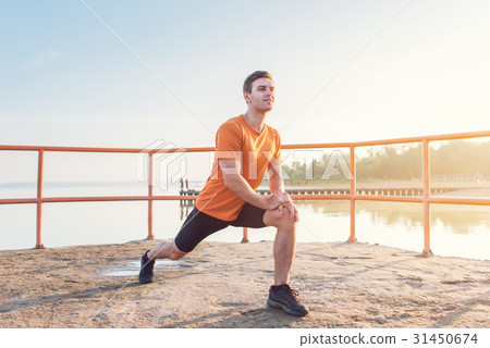 Young fit man stretching legs outdoors doing 31450674